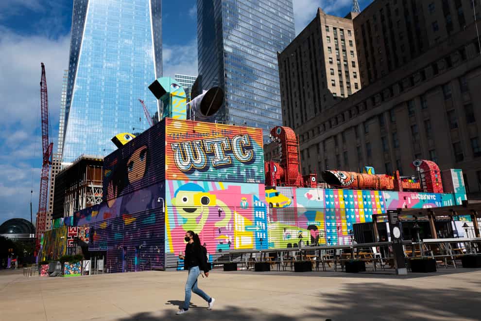 A woman walks by the colourful murals that surround the foundation for 2 World Trade Centre in New York (AP Photo/Mark Lennihan)