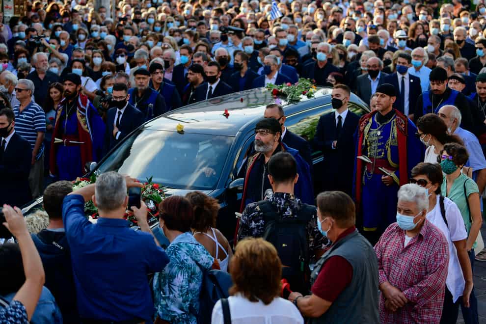 Men in traditional dress of the island of Crete escort a hearse, ahead of the burial of Greek composer Mikis Theodorakis in Crete (AP Photo/Michael Varaklas)