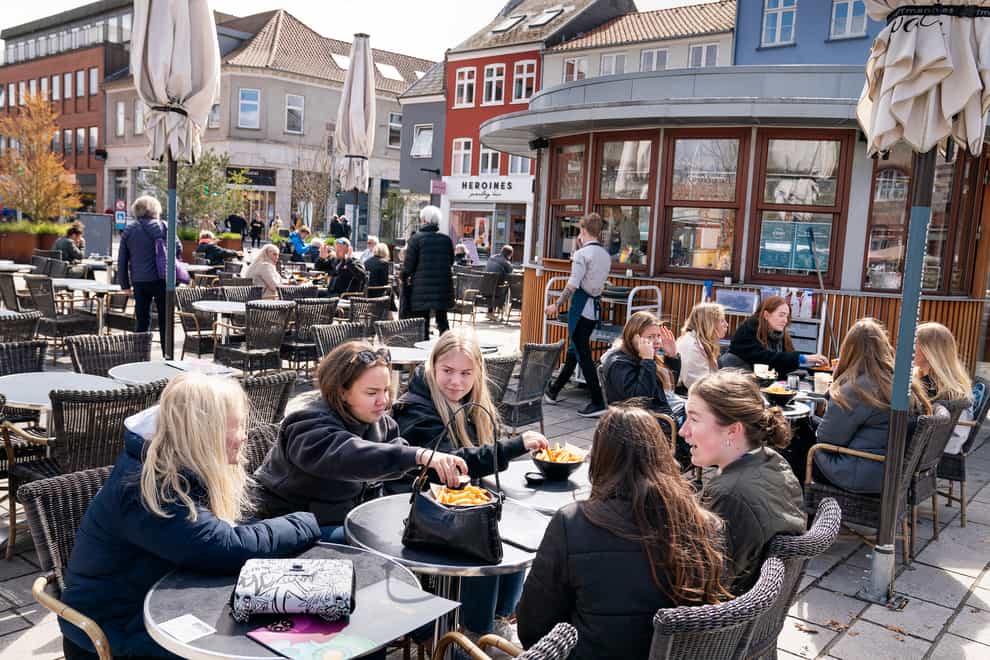 People sit outside a restaurant for outdoor service in Roskilde Denmark (Claus Bech/Ritzau Scanpix via AP, File)
