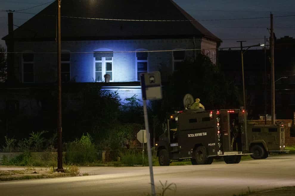 Illinois State Police in armoured trucks shine a spotlight on a building during a manhunt after a shooting in southern Illinois (Daniel Shular/St. Louis Post-Dispatch via AP)