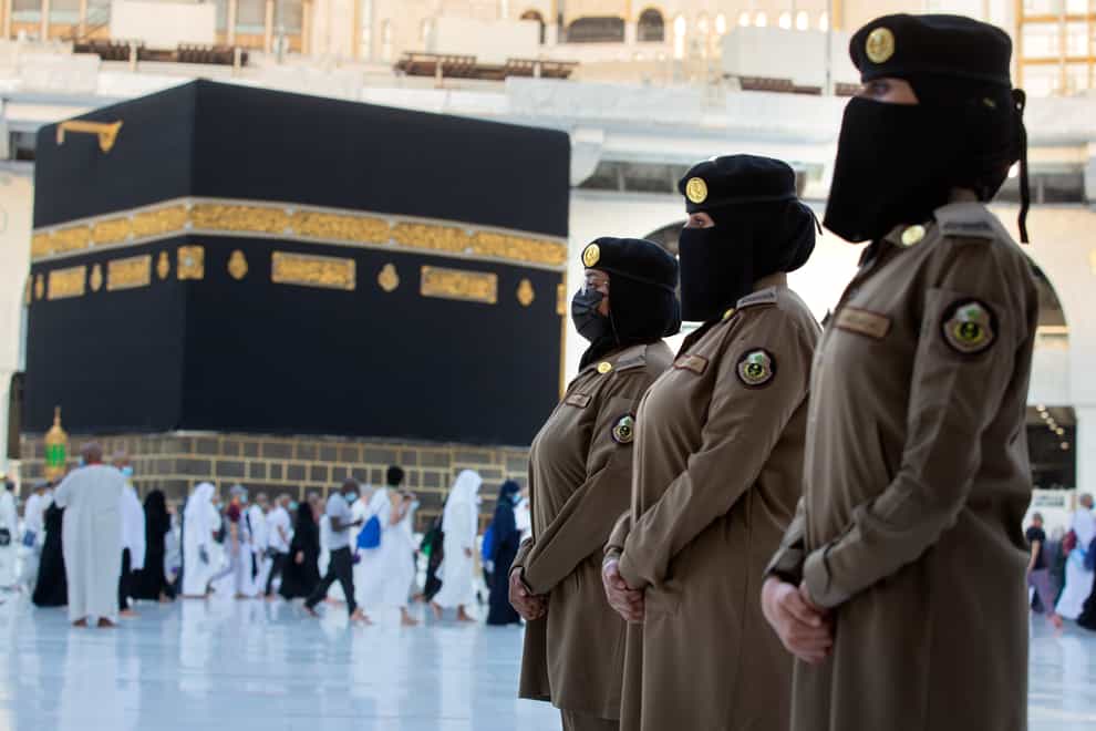 Saudi police women, who were recently deployed to the service, from right to left, Samar, Alaa, and Bashair, stand alert in front of the Kaaba, the cubic building at the Grand Mosque, during the annual hajj pilgrimage (Amr Nabil/AP)
