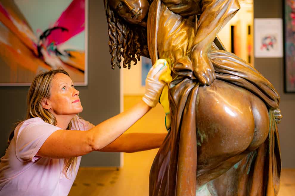 Vanguard exhibition director Mary McCarthy polishes the life-sized bronze artwork (PA)