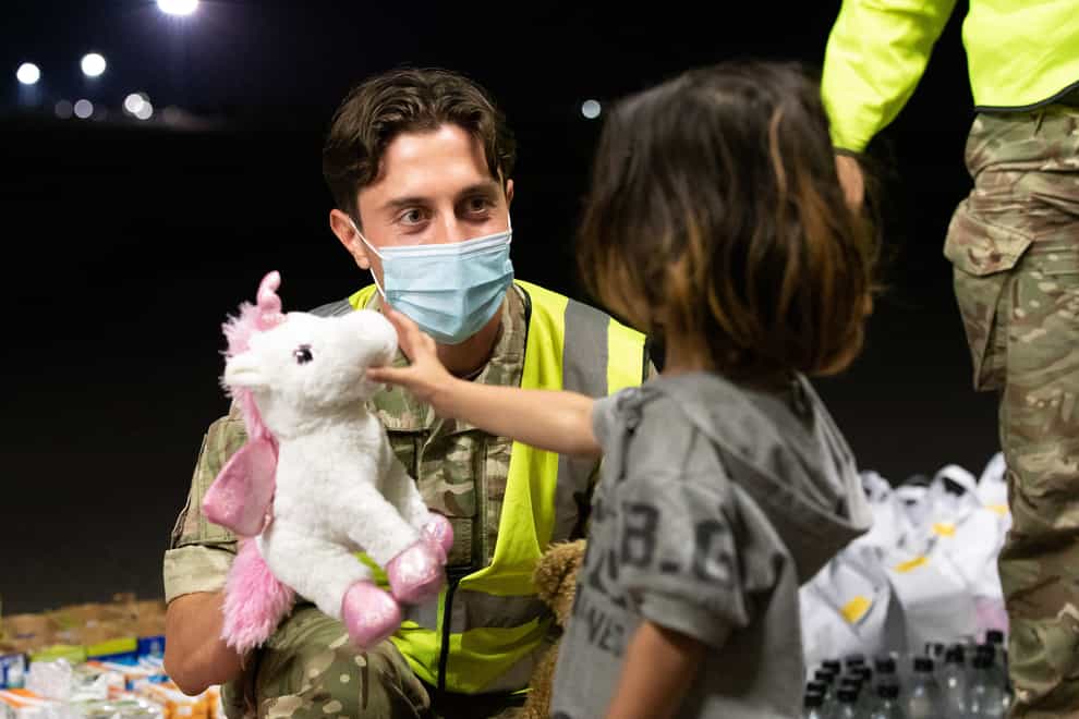 Military personnel handing out food, drink, toys, and blankets during Operation Pitting at RAF Brize Norton (Cpl Will Drummee RAF/MOD/Crown copyright)