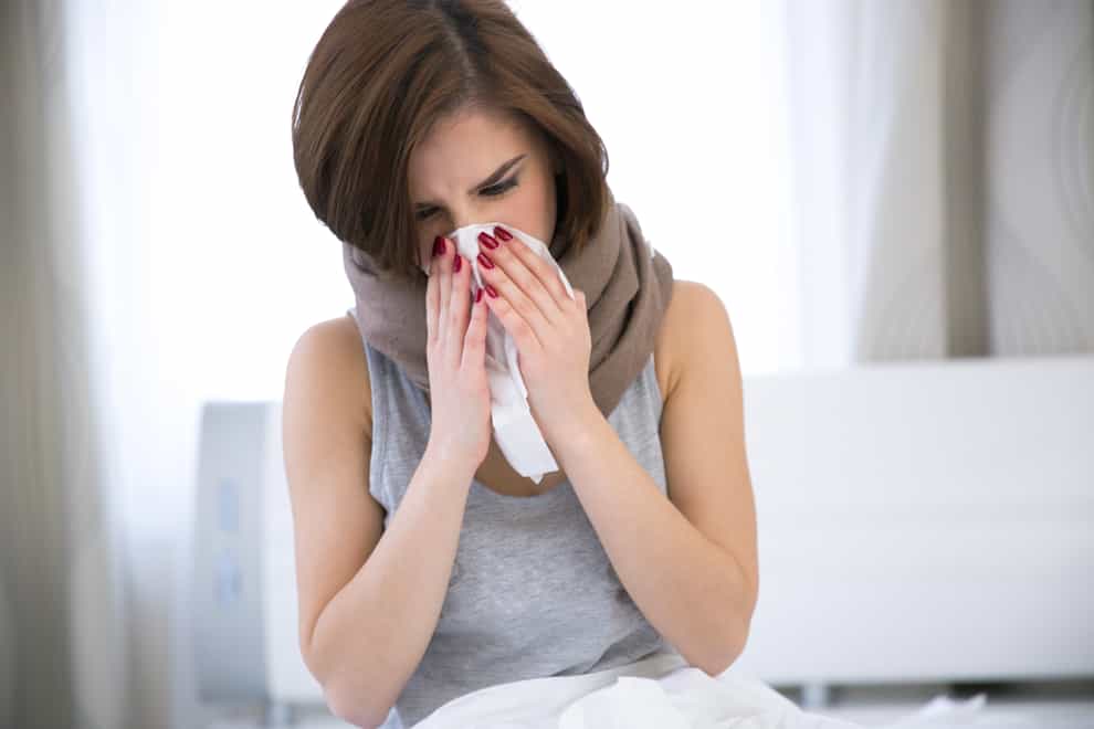 Woman suffering from flu (Alamy/PA)