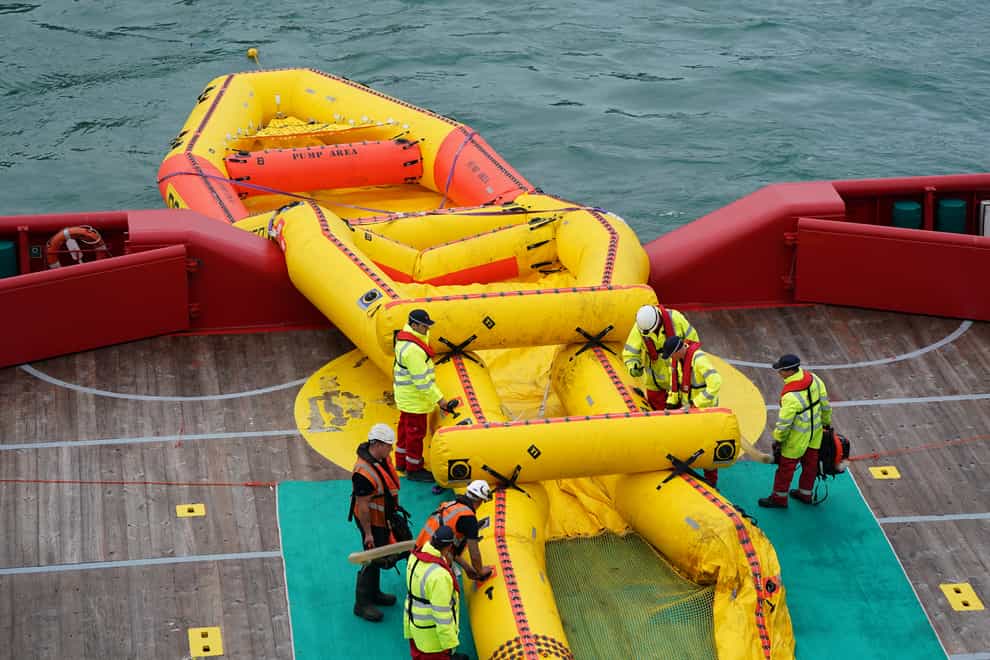 Members of the Maritime and Coastguard Agency deploy a giant inflatable counter-pollution kit named the Current Buster 6 (Andrew Matthews/PA)
