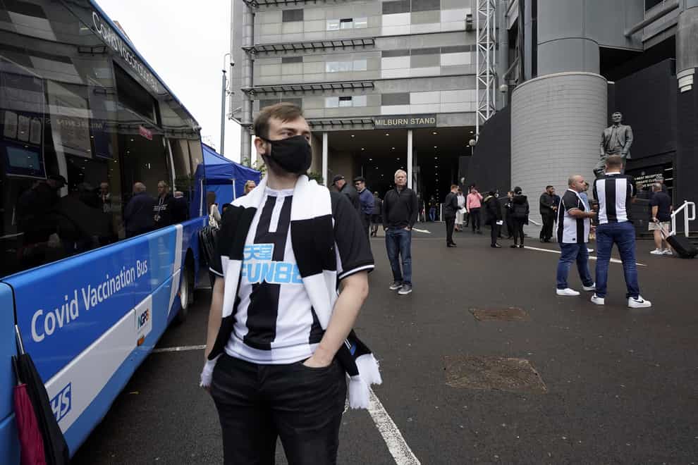 A Newcastle United fan waits for a Covid-19 dose at a vaccination bus outside the St James’ Park stadium (Owen Humphreys/PA)