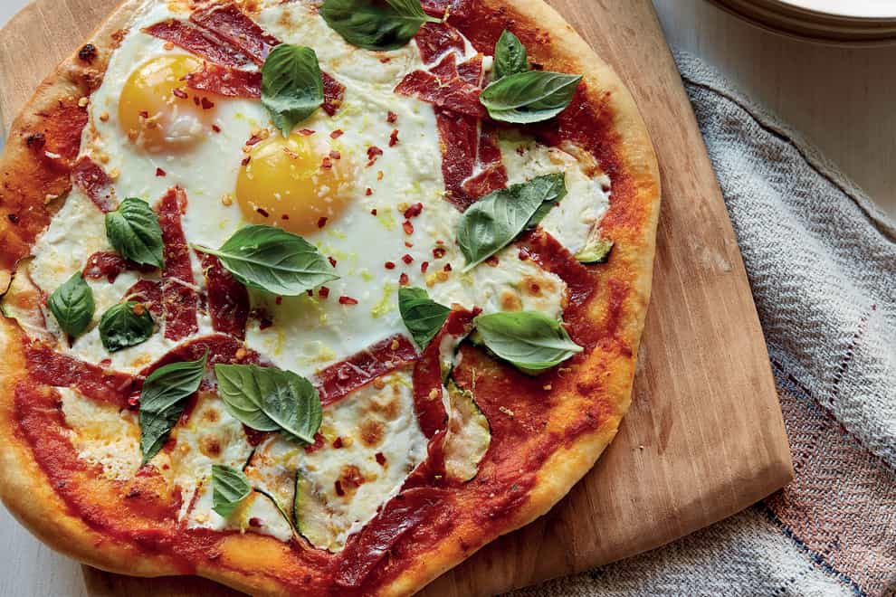 Breakfast for dinner pizza with eggs, courgette and spicy salami (Paul Brissman/PA)