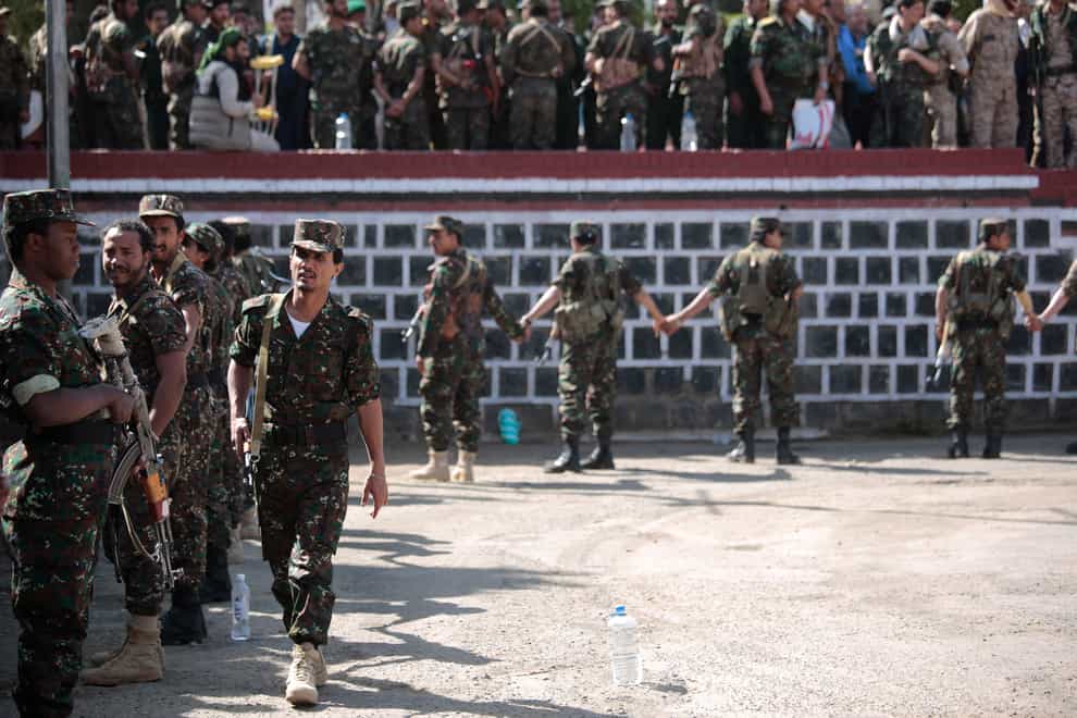 Soldiers stand guard during the execution of nine men (Hani Mohammed/AP)