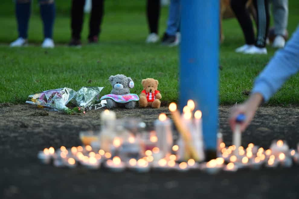 Flowers, soft toys and candles are seen at a vigil at the scene (Anthony Delvin/PA)