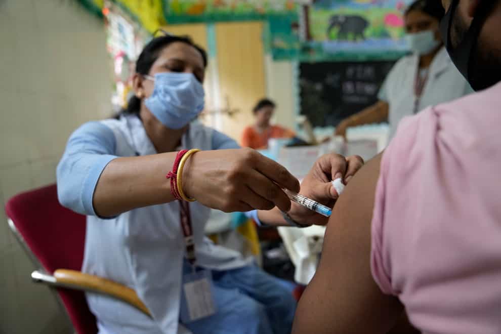 A health worker administers the vaccine at a centre set up at a government-run school in New Delhi, India (AP Photo/Manish Swarup)