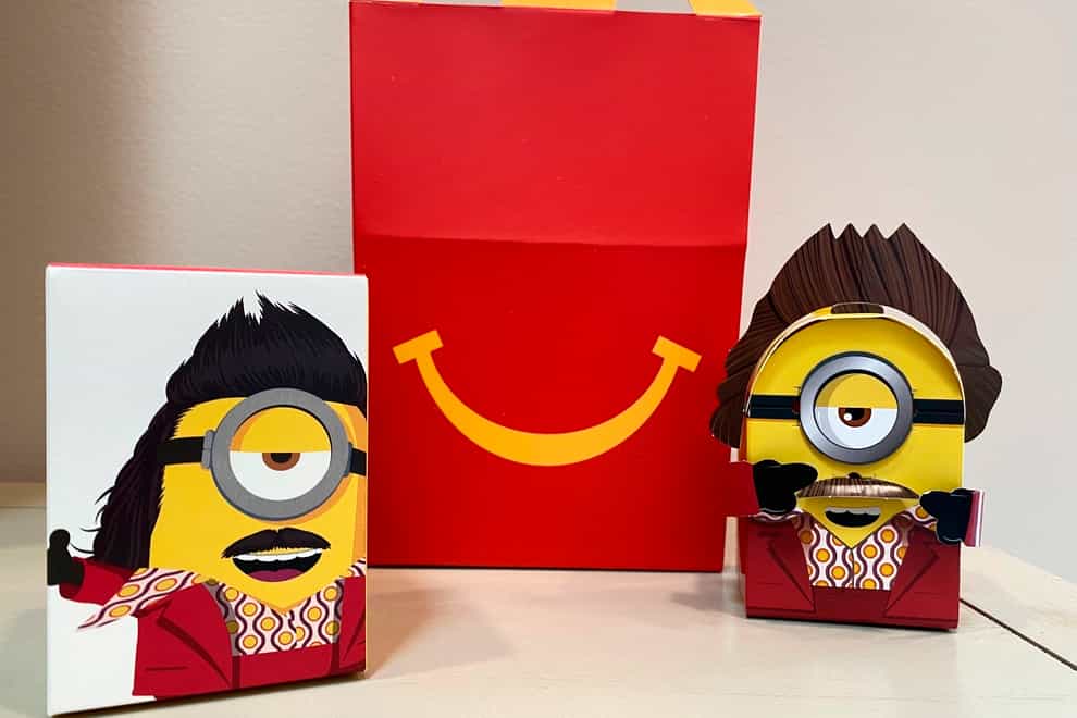 A cardboard McDonald’s Happy Meal toy is shown with a Happy Meal box on Sept. 20, 2021. McDonald’s plans to “drastically” reduce the plastic in its Happy Meal toys worldwide by 2025. The burger giant said Tuesday, Sept. 21 it’s working with toy companies to develop new ideas, such as three-dimensional cardboard superheroes kids can build or board games with plant-based or recycled game pieces. (AP Photo/Dee-Ann Durbin)