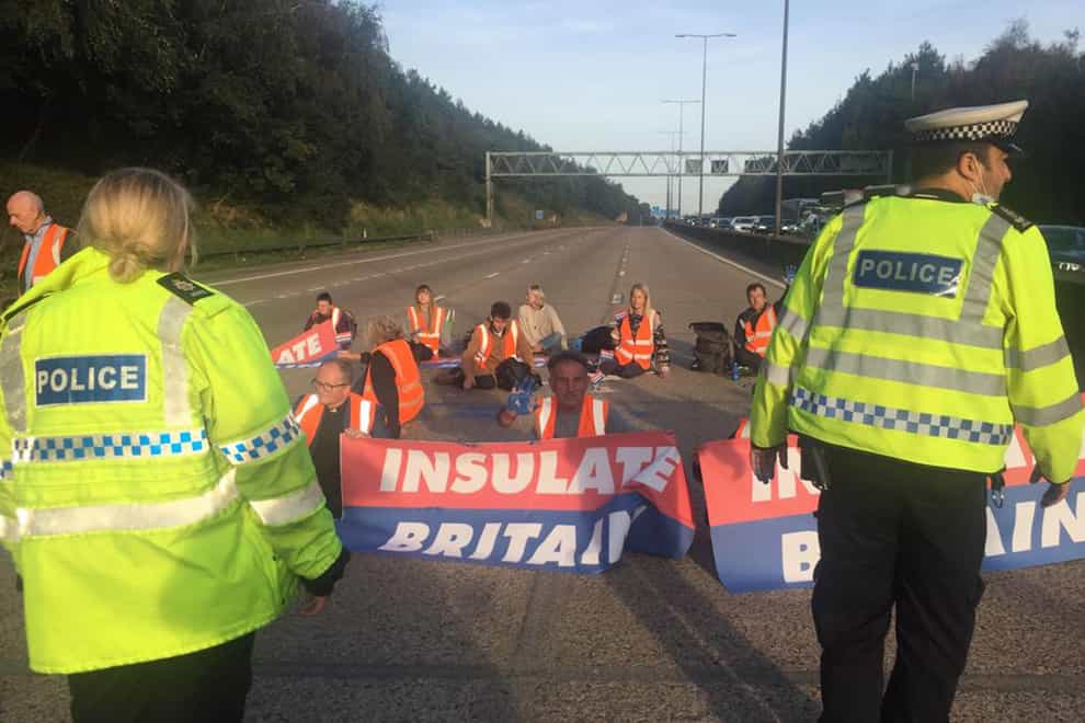 Handout photo issued by Insulate Britain of protesters occupying the clockwise and anti-clockwise lanes on the M25 in Surrey