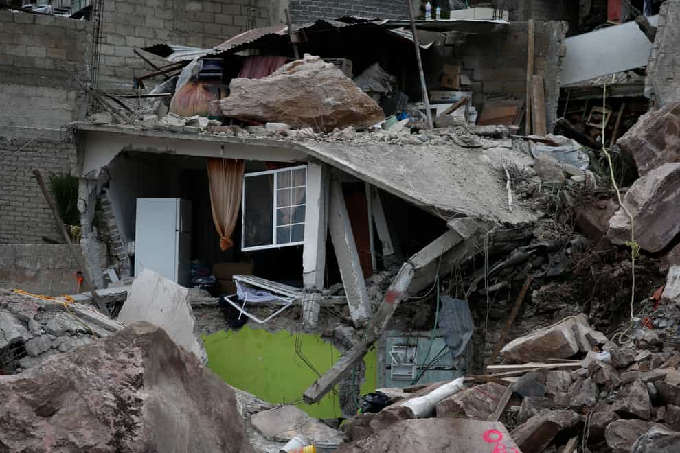 Boulders and debris that plunged from a mountainside rest atop homes in Tlalnepantla, on the outskirts of Mexico City (AP Photo/Ginnette Riquelme)