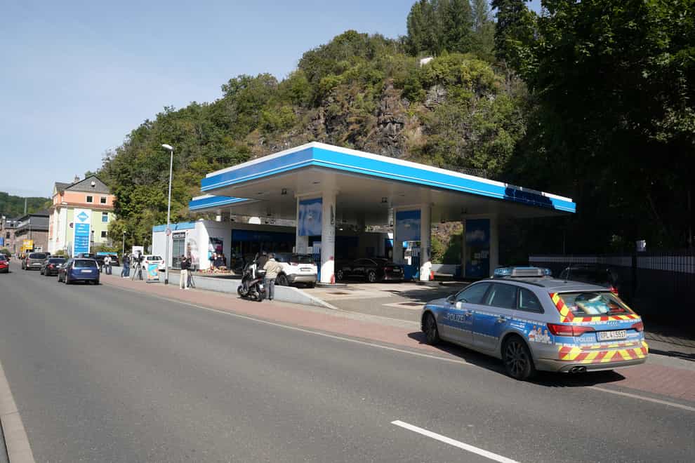 Media and police in front of a petrol station in Idar-Oberstein, Germany. A 49-year-old man has been arrested on suspicion of murder (Thomas Frey/dpa via AP)