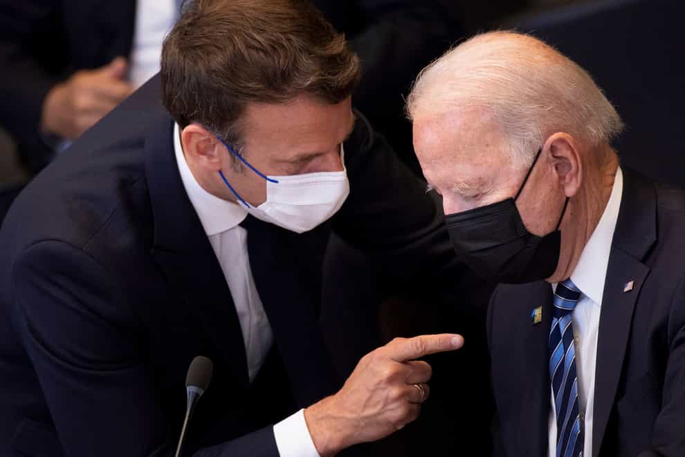 Joe Biden speaks to Emmanuel Macron during during a Nato summit (Brendan Smialowski, Pool/AP)