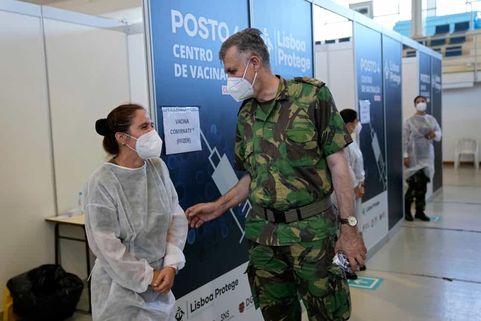 Rear Admiral Henrique Gouveia e Melo shares a joke with a military nurse during a visit to a vaccination centre in Lisbon (Armando Franca/AP)