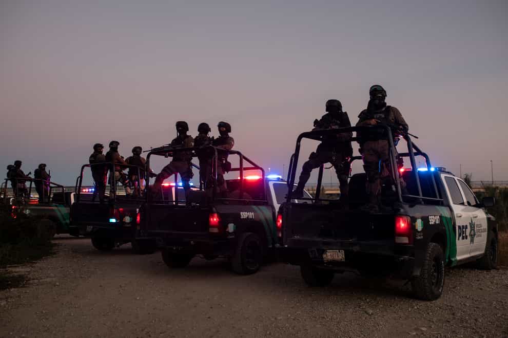 Mexican police stand guard near the Rio Grande river in Ciudad Acuna, Mexico, at dawn (AP Photo/Felix Marquez)