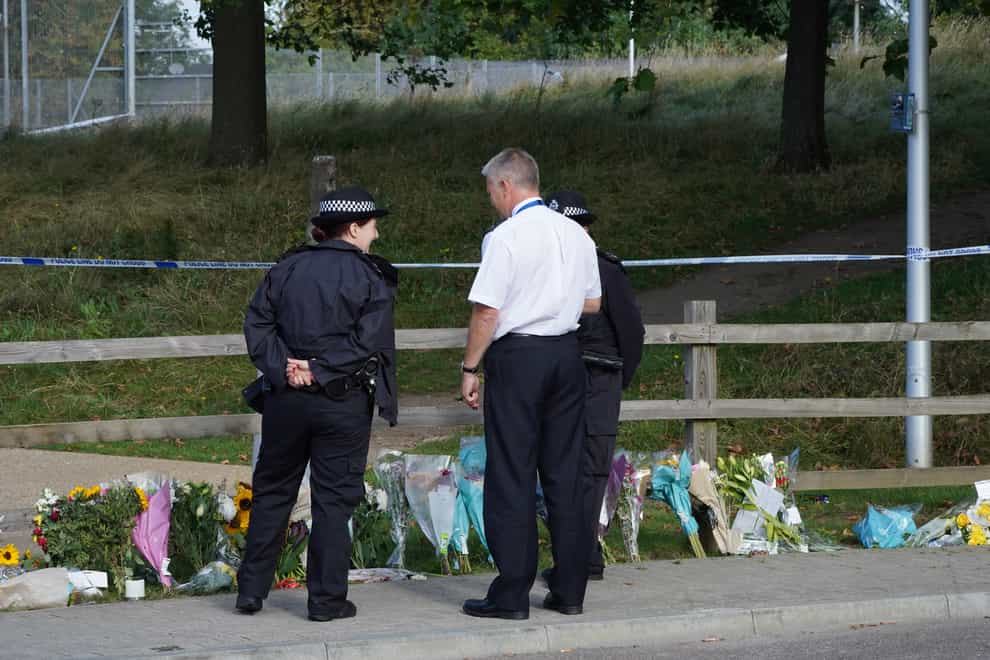 Police officers stand by floral tributes at Cator Park in Kidbrooke (Ian West/PA)