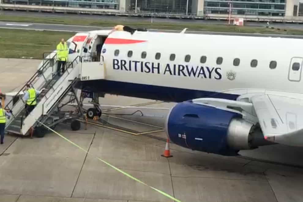 Paralympian James Brown lying top of a British Airways plane at City Airport, London (Extinction Rebellion/PA)