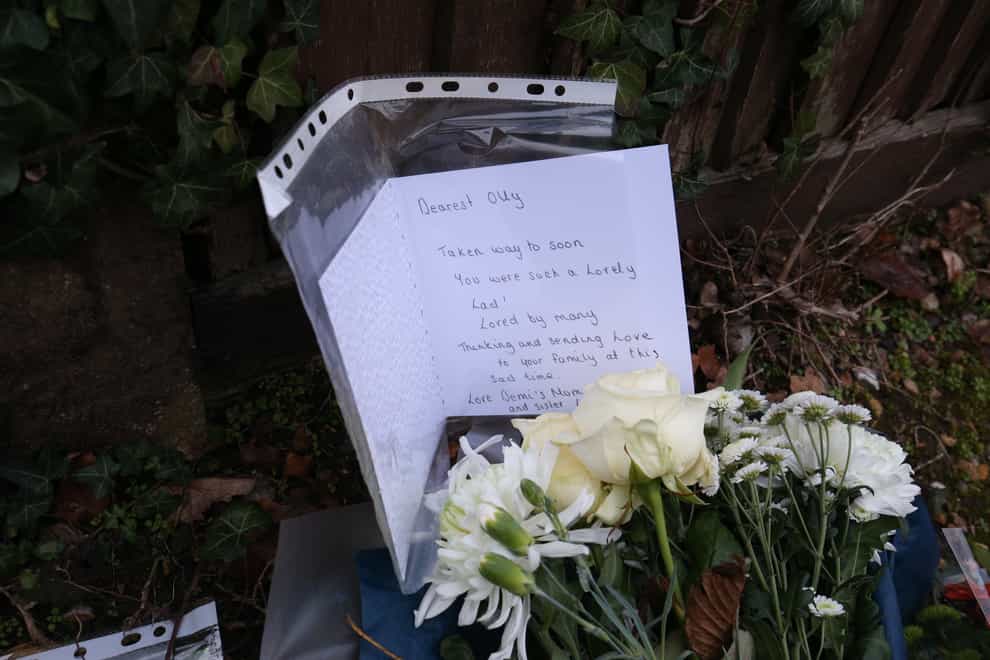 Floral tributes and a card left outside Highdown School in Reading after Olly’s murder (PA)