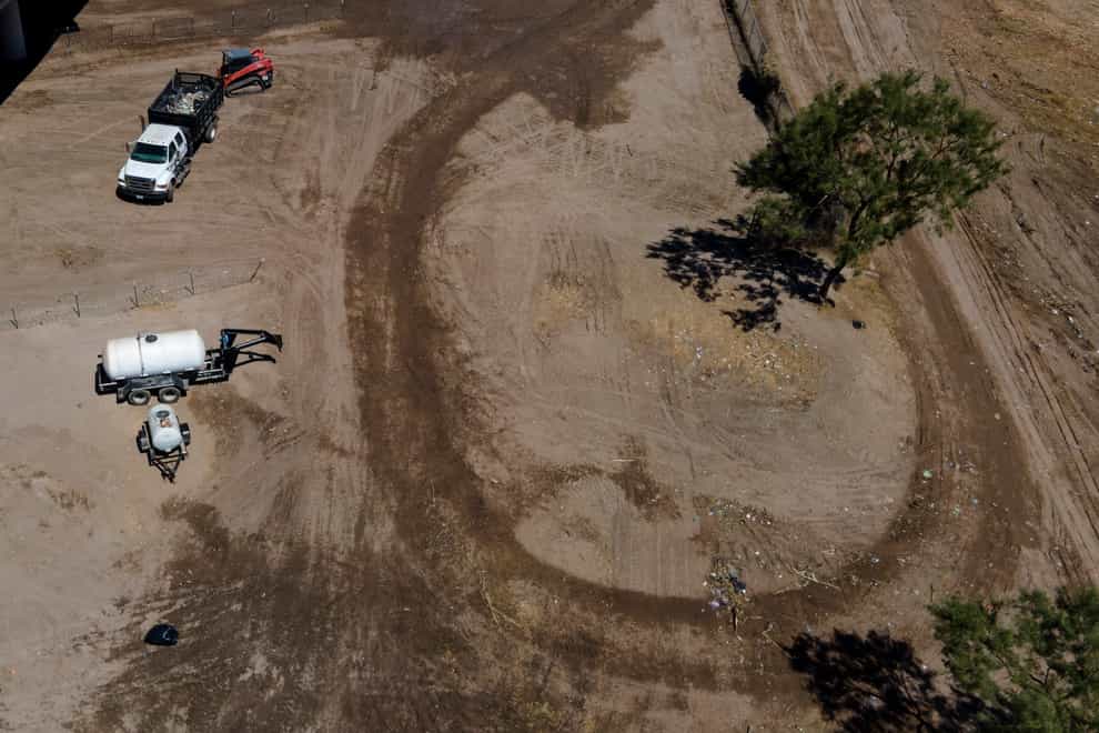 Crews clear an area which was occupied by migrants in Texas (Julio Cortez/AP)