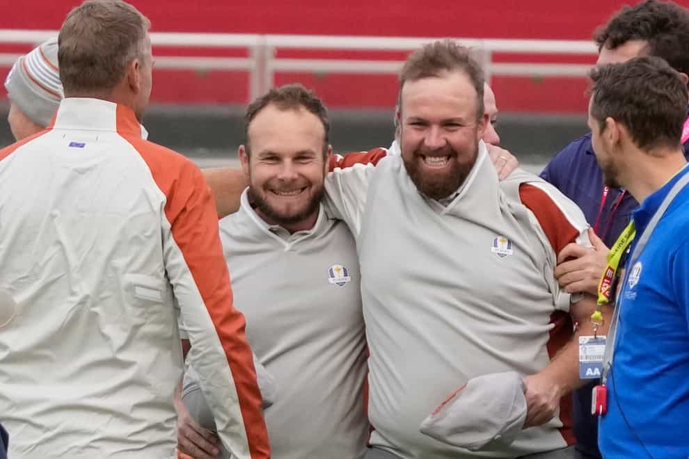 Shane Lowry and Tyrrell Hatton celebrate on the 18th hole after winning their four-ball match on day two of the Ryder Cup (Charlie Neibergall/AP)