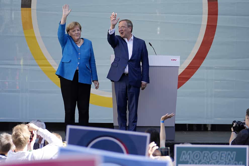 Chancellor Angela Merkel and Governor Armin Laschet wave to supporters at an election campaign event (Martin Meissner/AP)