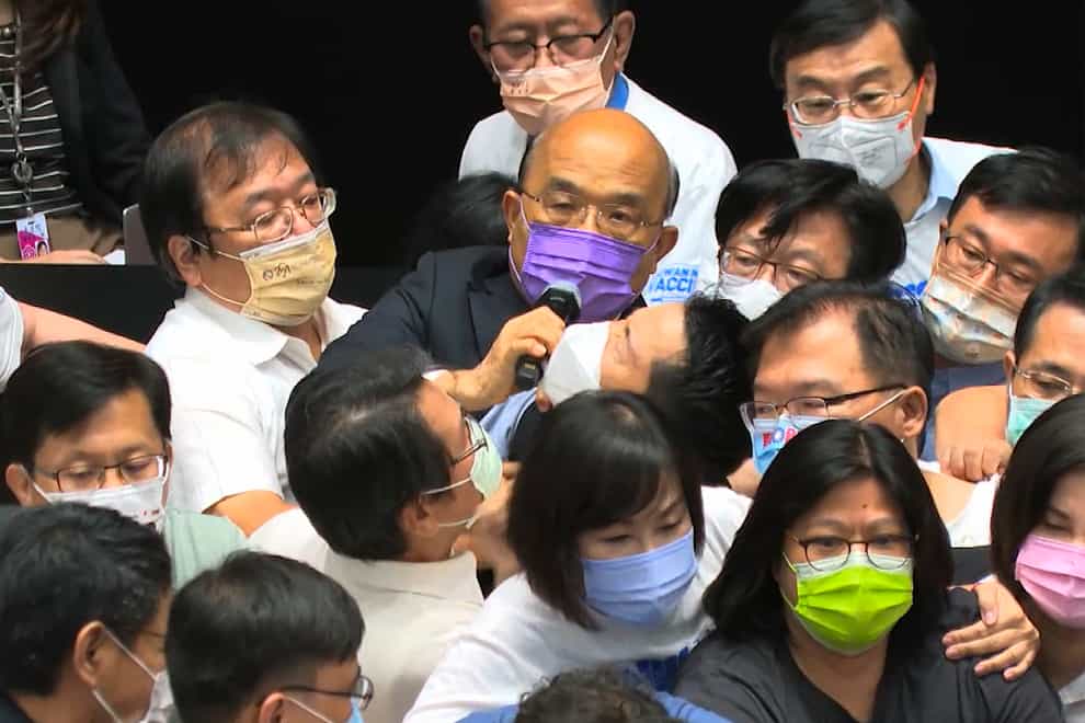 Premier Su Tseng-chang, in purple mask, tries to make a policy speech amid a scuffle between opposition Nationalist party and ruling Democratic Progressive Party lawmakers (EBC/AP)