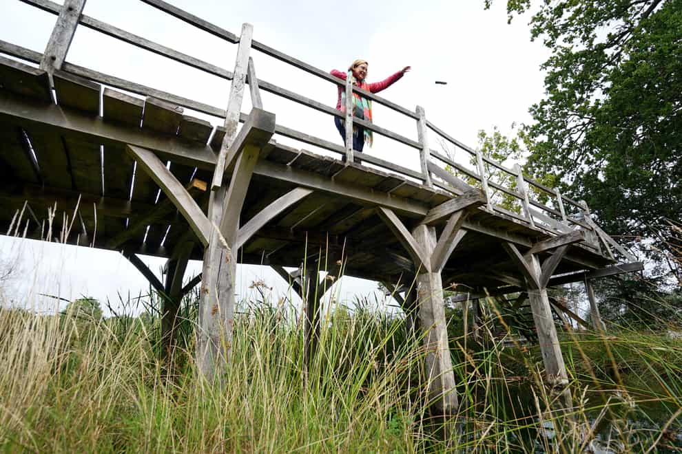 Silke Lohmann of Summers Place Auctions stands on the original Poohsticks Bridge from Ashdown Forest (Gareth Fuller/PA)