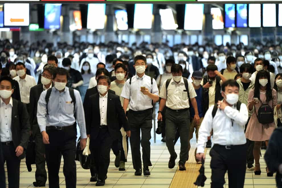 Commuters wearing face masks on their return to work (Eugene Hoshiko/AP)
