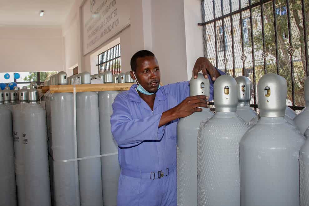 A worker shows oxygen cylinders during an event to unveil a new oxygen plant at Banadir hospital in Mogadishu, Somalia (Farah Abdi Warsameh/AP)