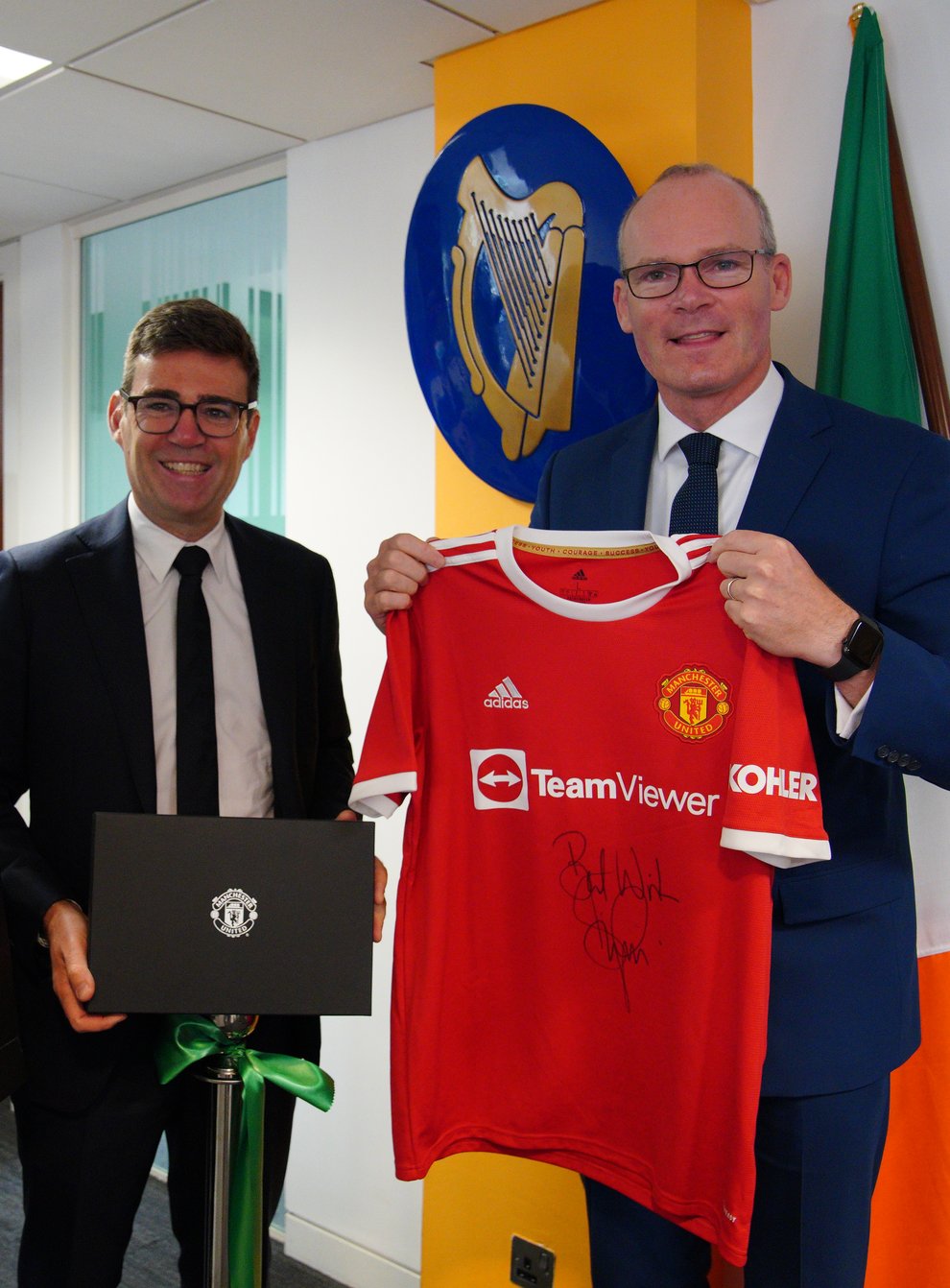 Foreign Affairs Minister Simon Coveney being presented with a signed Denis Irwin Manchester United FC shirt by Stockport Council Leader Elise Wilson and mayor of Greater Manchester, Andy Burnham, in Manchester, at the official opening of the Consulate General of Ireland for the North of England (Peter Byrne/PA)