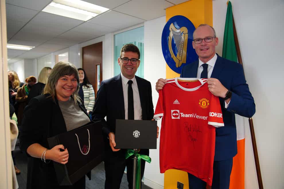 Foreign Affairs Minister Simon Coveney being presented with a signed Denis Irwin Manchester United FC shirt by Stockport Council Leader Elise Wilson and mayor of Greater Manchester, Andy Burnham, in Manchester, at the official opening of the Consulate General of Ireland for the North of England (Peter Byrne/PA)