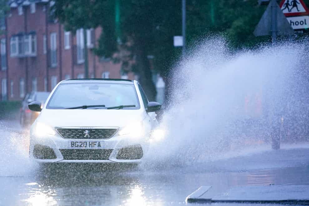 Cars drive through standing water after heavy overnight rain showers in Warwick, Warwickshire (Jacob King/PA)