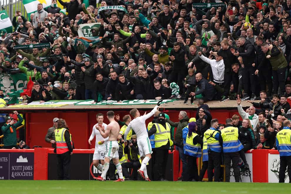 Celtic players and fans celebrate a long-awaited away win (Andrew Milligan/PA)