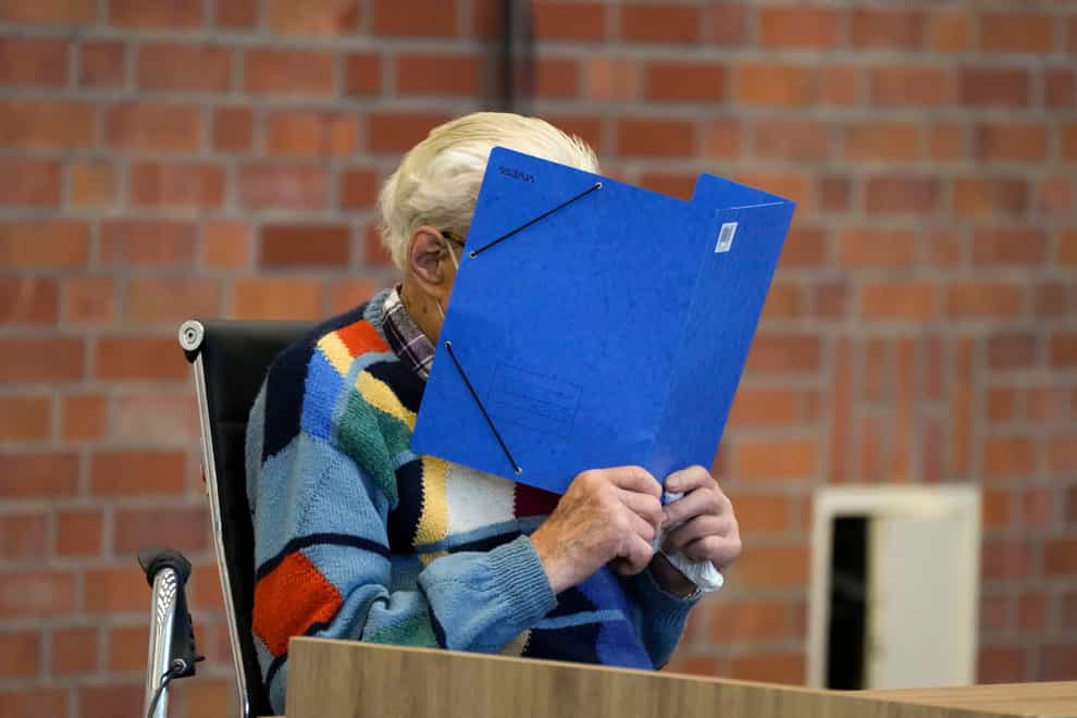 The accused Josef S covers his face as he sits at the court room in Brandenburg, Germany (Markus Schreiber/AP)