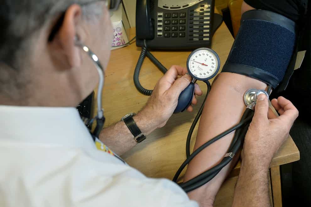 A GP checking a patient’s blood pressure. GPs and other medics are feeling burnt out (Anthony Devlin/PA)