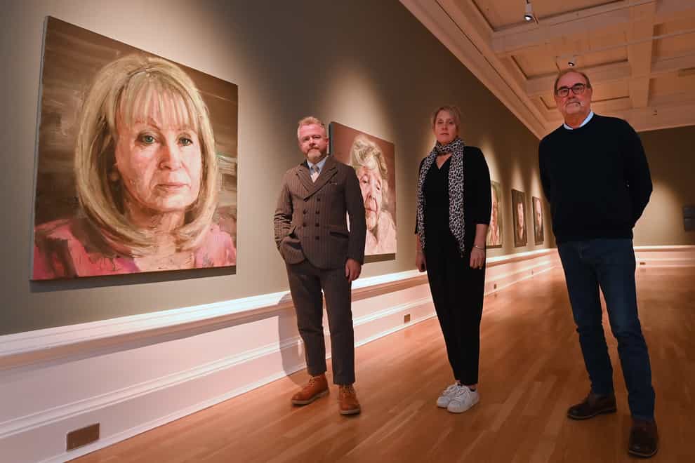 (l-r) With Mo Norton’s portrait are artist Colin Davidson, Kathryn Thomson, chief executive of National Museums NI ,and Dennis Godfrey of WAVE (NMNI/PA)