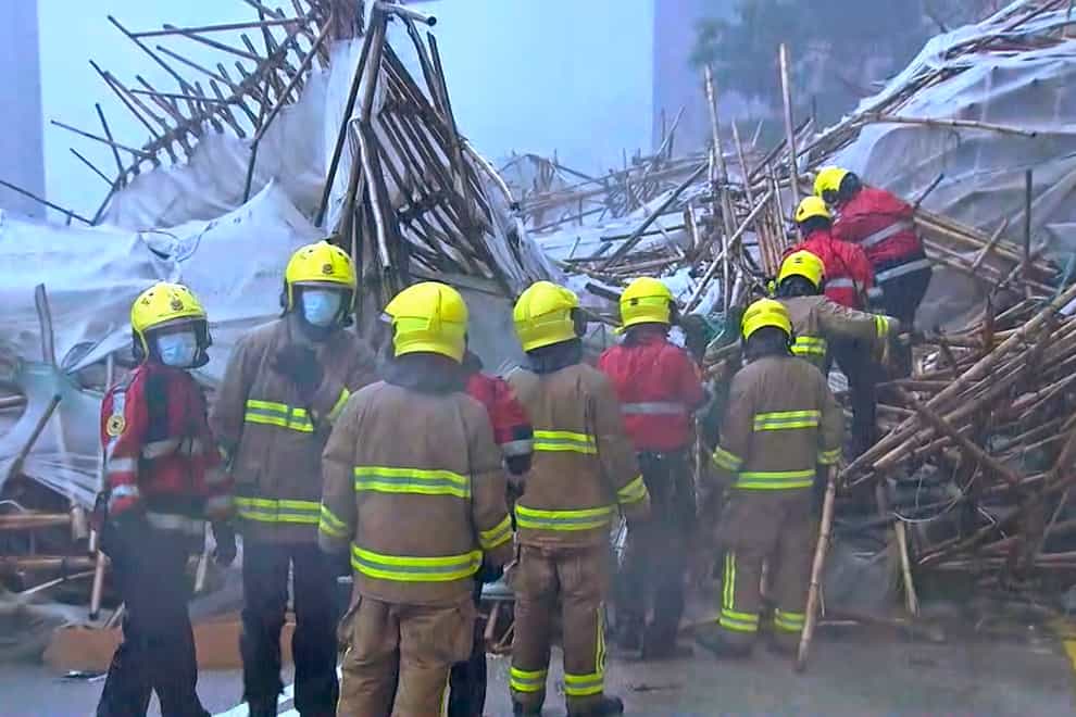 In this image made from video provided by TVB, firefighters work at the scene of a section of an apartment building scaffolding that collapsed during heavy weather in Hong Kong, Friday, Oct. 8, 2021. The official Hong Kong Observatory issued a Black Rainstorm Signal Friday, which indicates rainfall of more than 70 millimeters (2.76 inches) per hour all over the territory, and instructed people to “stay indoors or take shelter in a safe place”. (TVB via AP Video)