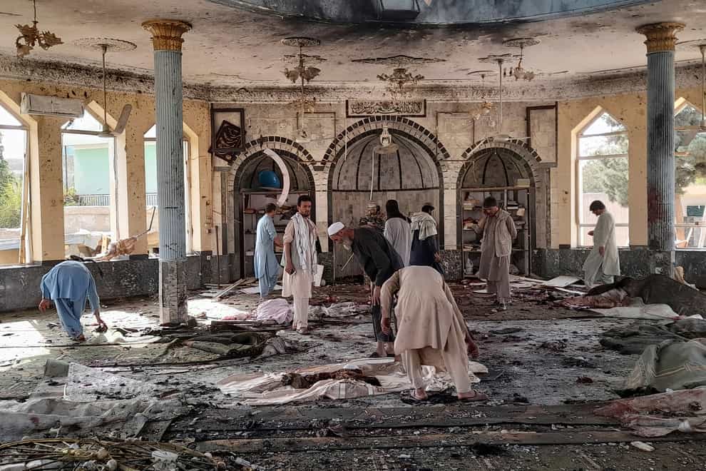 People view the damage inside of a mosque following a bombing in Kunduz, province northern Afghanistan, Friday, Oct. 8, 2021. A powerful explosion in the mosque frequented by a Muslim religious minority in northern Afghanistan on Friday has left several casualties, witnesses and the Taliban’s spokesman said. (AP Photo/Abdullah Sahil)