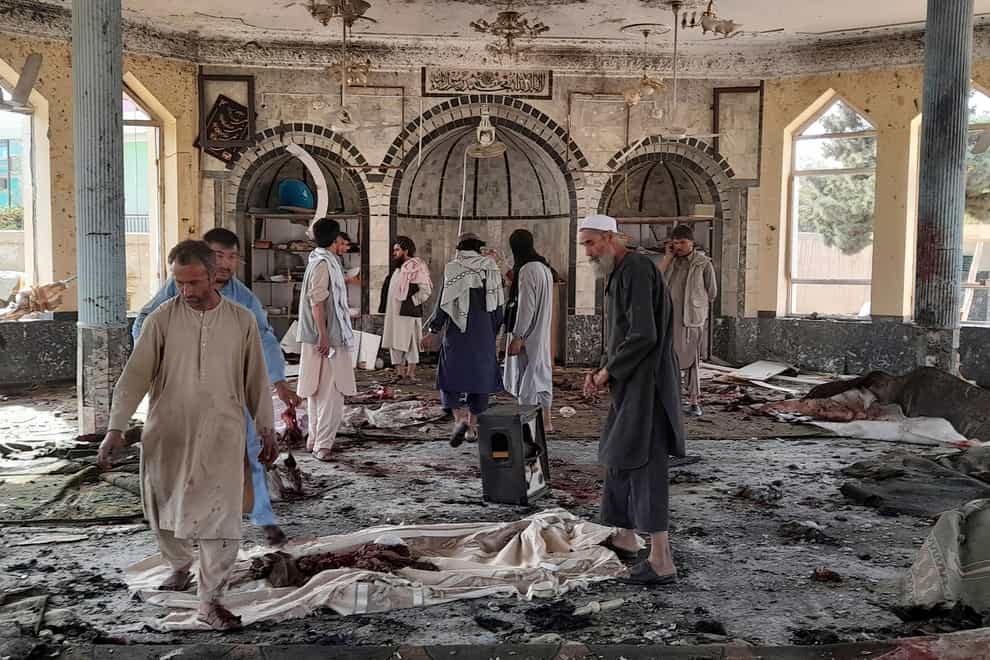 People view the damage inside of a mosque following a bombing in Kunduz (Abdullah Sahil/AP)