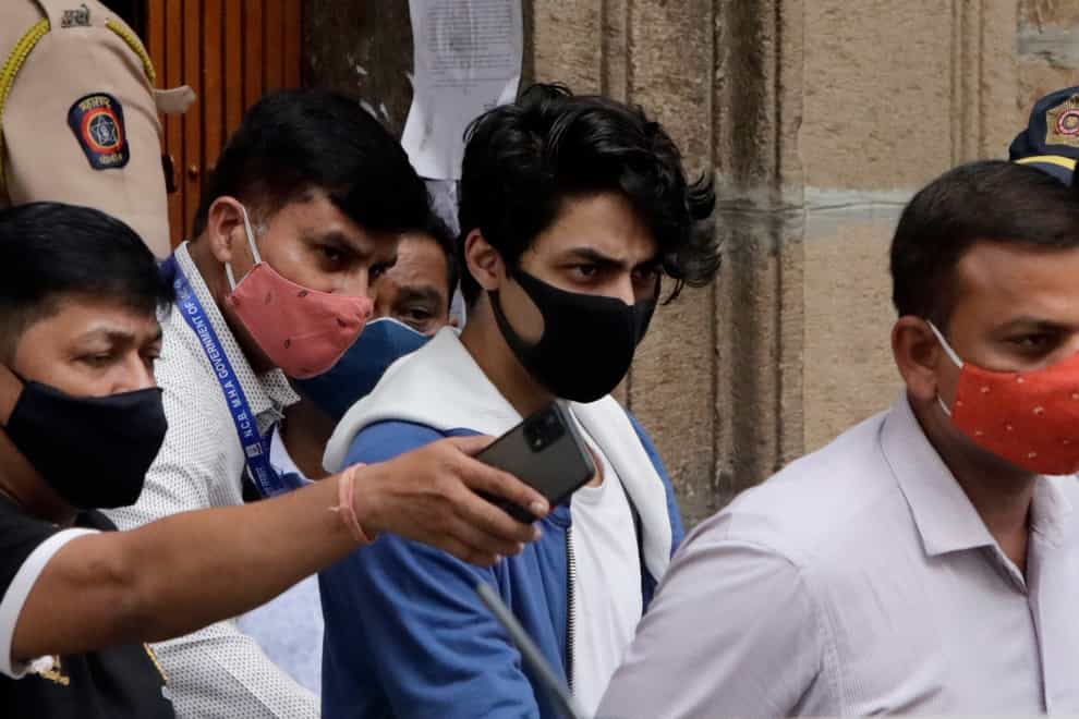 Bollywood actor Shah Rukh Khan’s son Aryan Khan, center, escorted by law enforcement officials from Narcotics Control Bureau office is being taken for a medical check up, in Mumbai, India, Friday, Oct. 08, 2021.(AP Photo/Rajanish kakade)