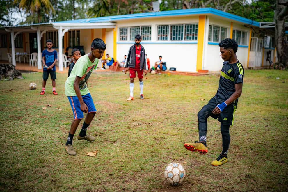 Young footballers pass the ball around during a coaching session at a training hub in Mauritius, where youngsters are given free sports training and coaching to help them pursue a career in professional sport (Ben Birchall/PA)