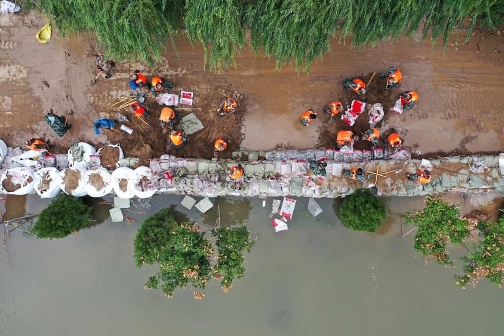 An aerial photo shows rescuers fortifying a temporary dyke against the flooding at the Lianbo Village in Hejin City (Xinhua via AP)