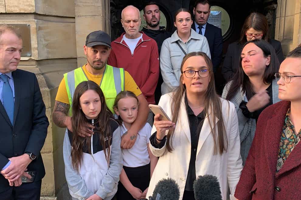 Tia Skelton, centre, the sister of Lewis Skelton, is surrounded by members of their family and solicitor Neil Hudgell, left, as she reads a statement to the media outside Hull Coroner’s Court (Dave Higgens/PA)