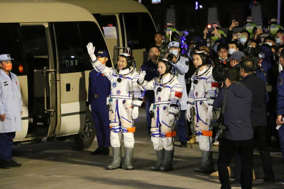 From left, Chinese astronauts Zhai Zhigang, Wang Yaping, and Ye Guangfu, wave before leaving for the Shenzhou-13 crewed space mission at the Jiuquan Satellite Launch Centre in northwest China (Chinatopix/AP)