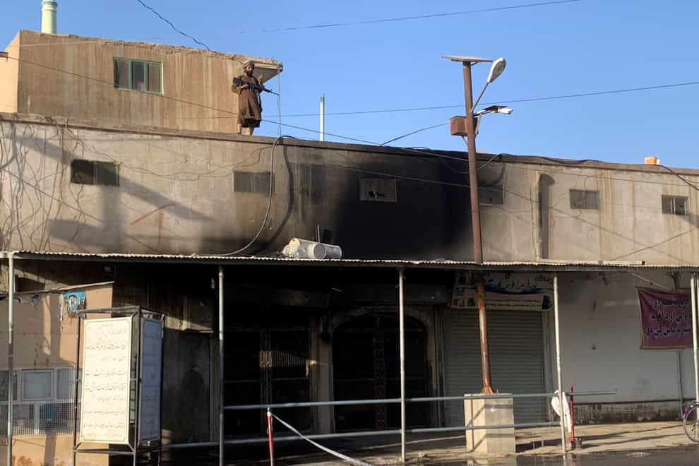A Taliban fighter stands guard on a mosque following a suicide bomb attack in the city of Kandaha (Sidiqullah Khan/AP)
