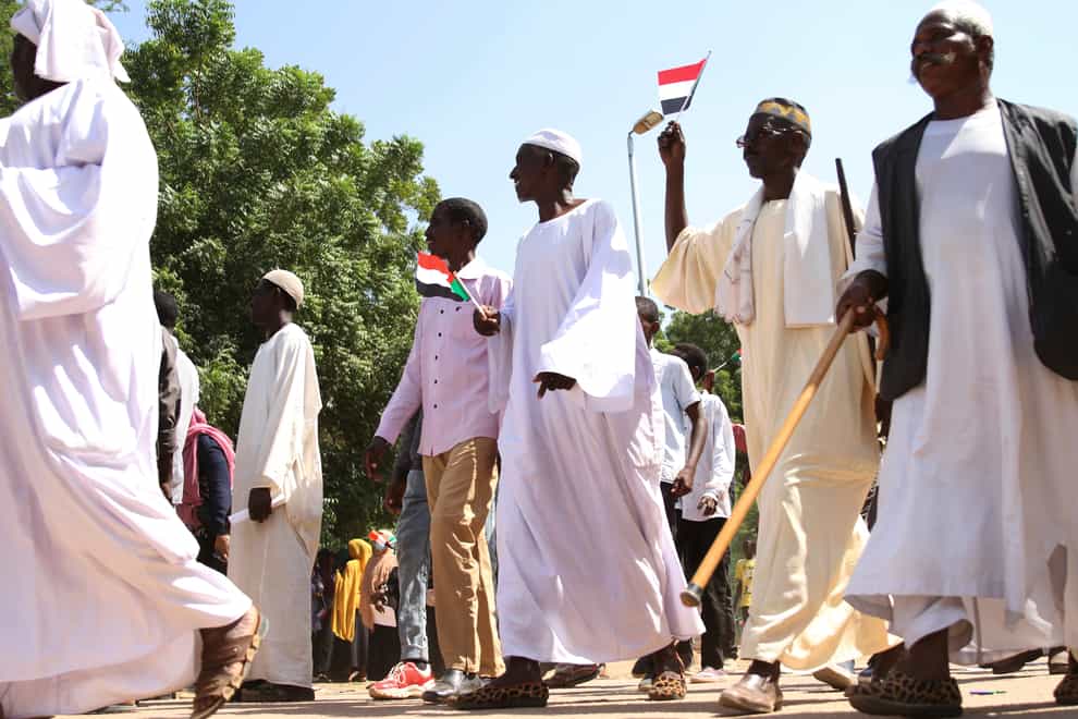 Sudanese protesters take part in a rally demanding the dissolution of the transitional government, outside the presidential palace in Khartoum, Sudan (Marwan Ali/AP)