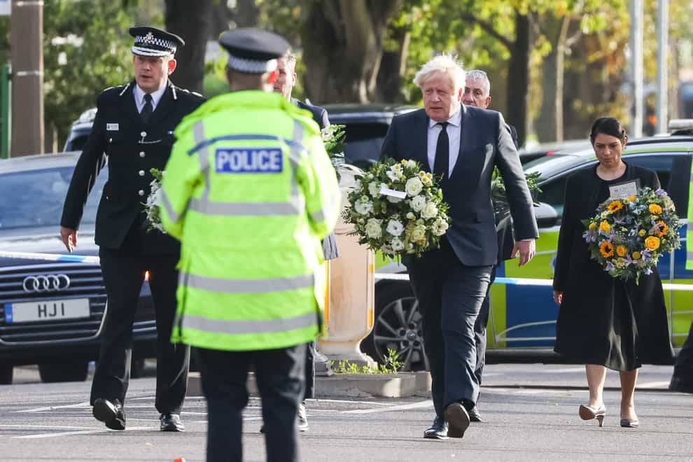 Chief Constable Ben-Julian Harrington, Labour leader Sir Keir Starmer, Prime Minister Boris Johnson and Home Secretary Priti Patel carry flowers as they arrive at the scene near Belfairs Methodist Church in Leigh-on-Sea, Essex, where Conservative MP Sir David Amess died after he was stabbed several times at a constituency surgery on Friday. (Dominic Lipinski/PA)