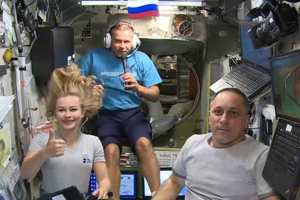 Actress Yulia Peresild, left, film director Klim Shipenko, centre, and cosmonaut Anton Shkaplerov aboard the ISS earlier this month (Roscosmos Space Agency/AP)